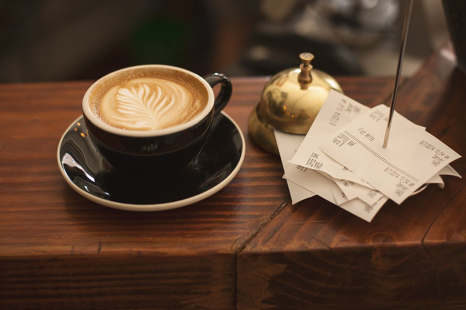 Receipts on a spike next to a cup of coffee